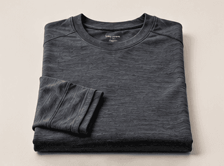 A folded merino base layer top on a clean light background.